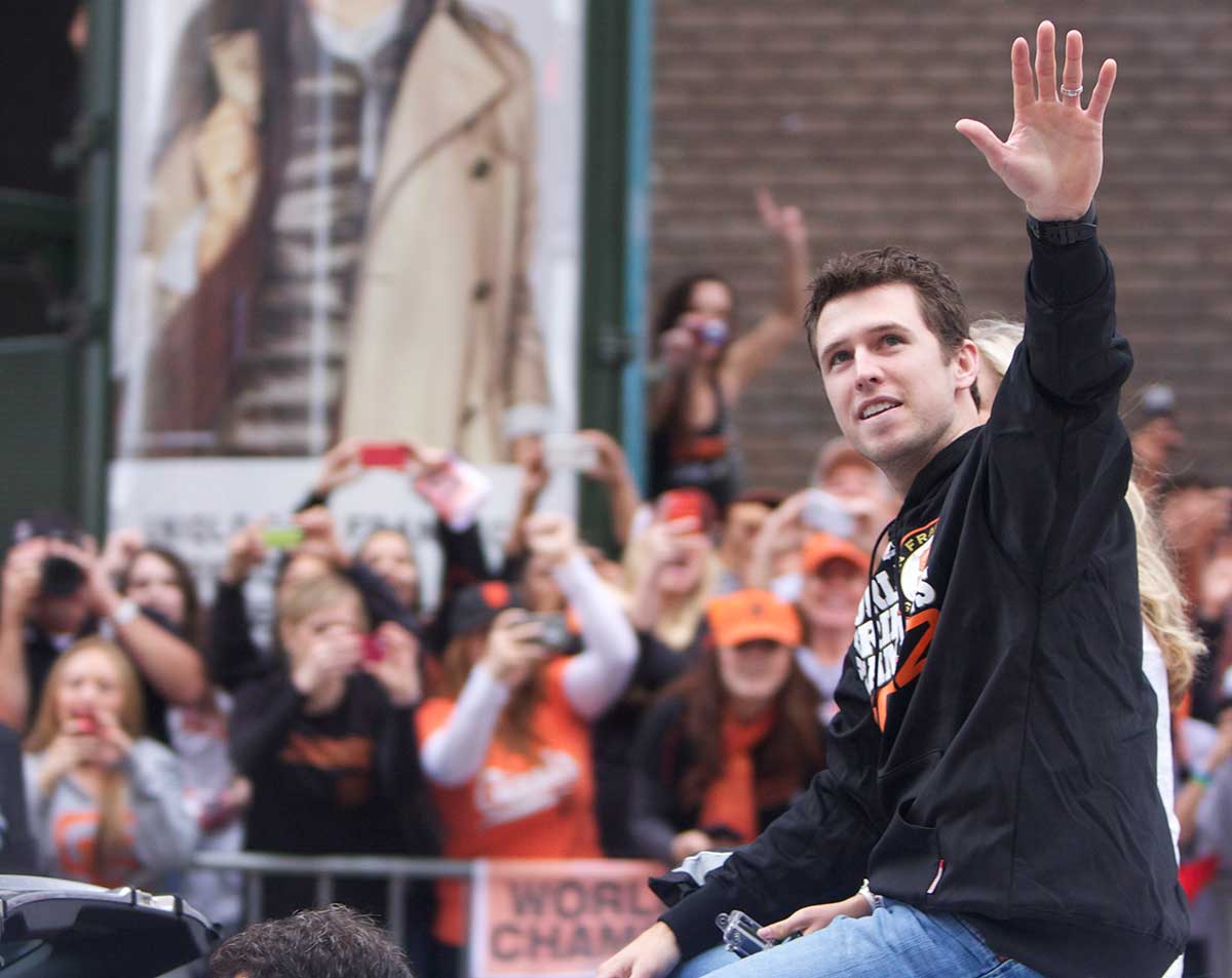 Giants catcher Buster Posey waves to fans during the Giants World Series parade down Market Street Wednesday